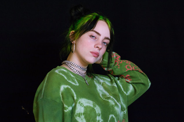 Billie Eilish menggunakan sweater hijau
